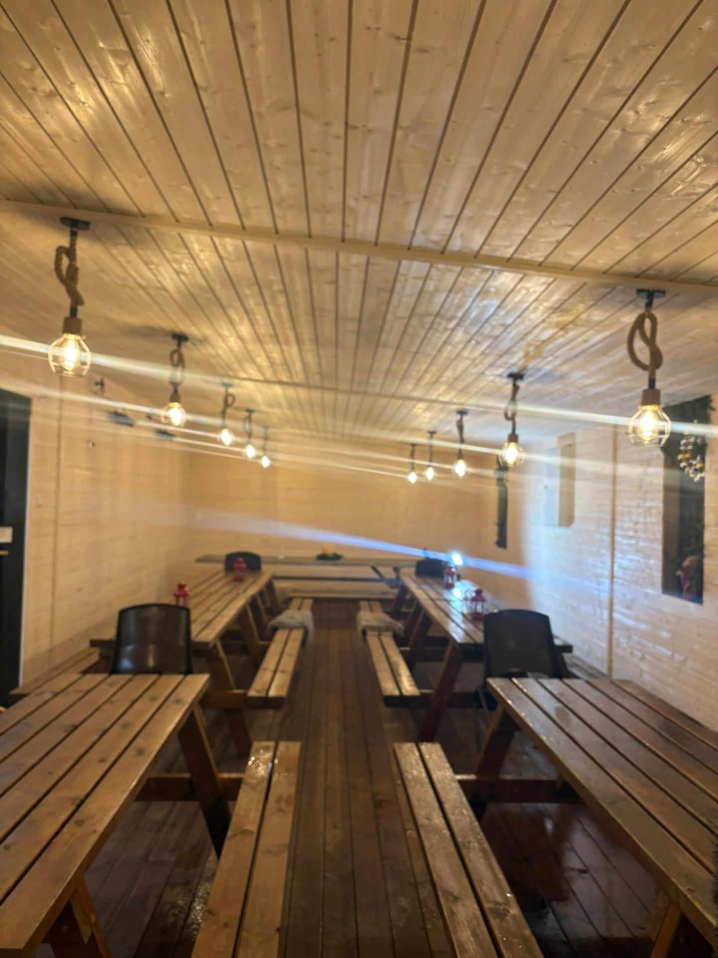 Innendørs festrom med langbord og lyssetting